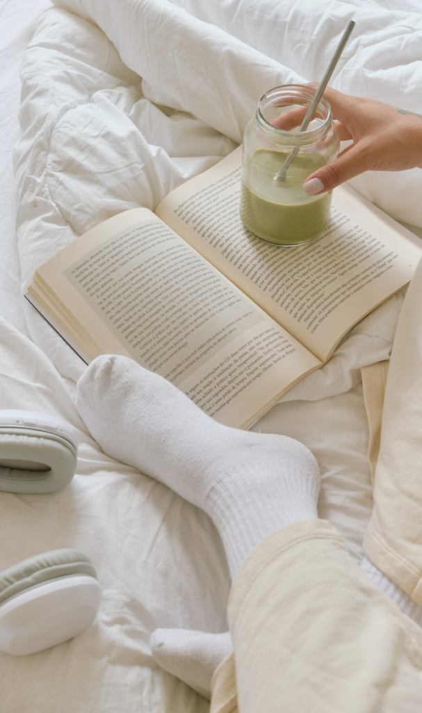 open book on cozy bed with matcha